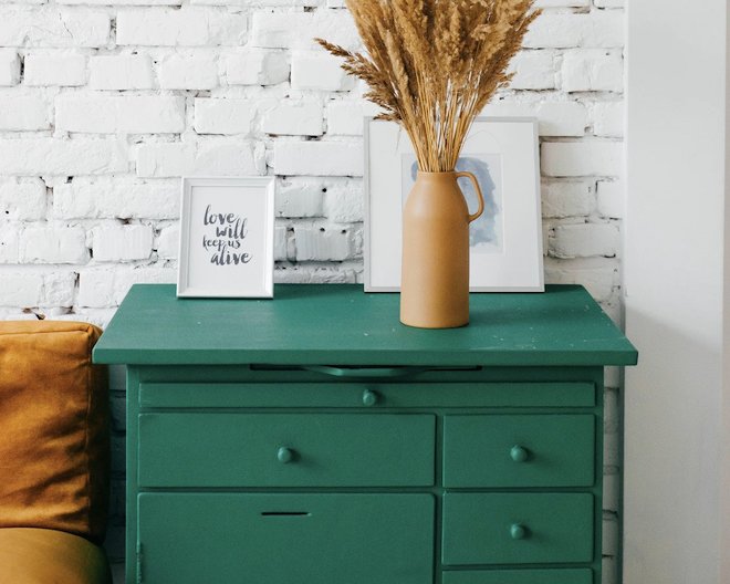 Green drawer with decorations in front of a white wall